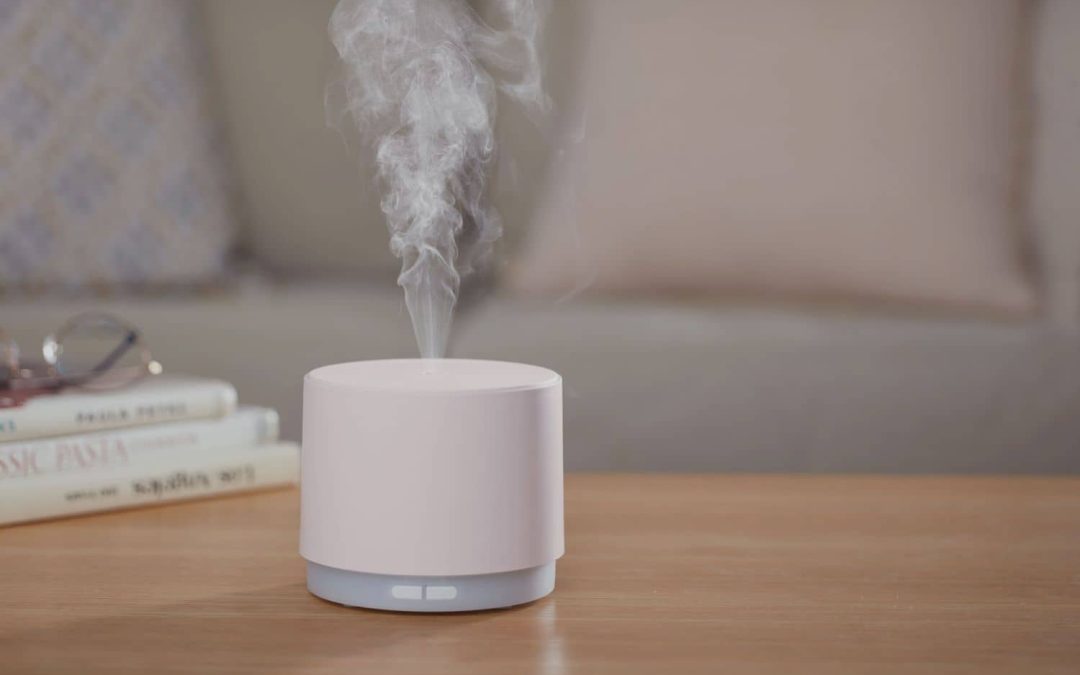 Humidifier releasing mist on a table in a home, raising indoor humidity that can cause mold